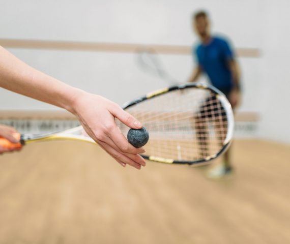 Young couple with rackets play squash game in indoor training club. Active sport lifestyle. Recreation workout, match with racquet